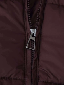 Macro detail of high-quality metal zipper on a dark burgundy puffer jacket