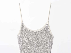 Detailed macro view of sparkling silver sequins on a stylish women's camisole dress