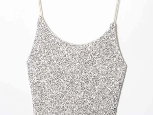 Detailed close-up of shiny silver sequins on a spaghetti strap dress with metallic finish