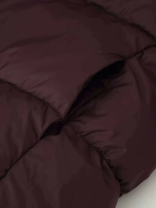 Close-up detail of quilted plum purple puffer jacket showing side pocket and stitching