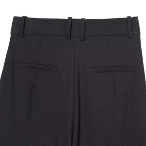 Back waist detail of black wide-leg trousers featuring belt loops and welt pockets