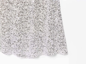 Detailed macro view of sparkling silver sequins fabric on a summer camisole dress