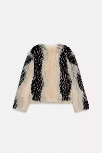 Close-up of luxury black and white striped faux fur jacket texture and soft plush fibers