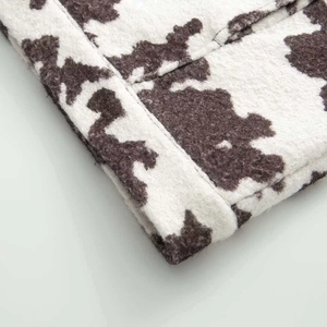 Close-up of cow print animal pattern fabric on a stylish autumn jacket sleeve
