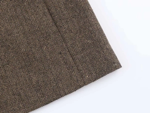 Close-up of brown and black herringbone woven fabric texture for autumn blazers