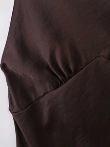 Detail of ruched design and silk-like satin fabric texture on the dark brown mini dress