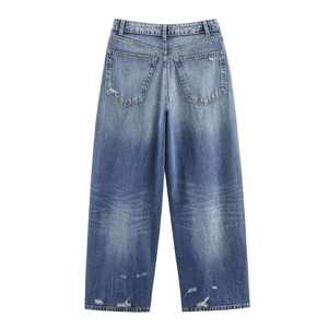 Détail de jean taille haute à jambe large en denim bleu avec poches arrière et ourlet déchiré