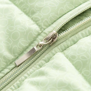 Détail de la veste matelassée vert clair avec broderie cœur et fermeture éclair argentée