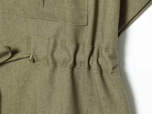 Detailed macro view of olive green linen fabric with elastic waist and metal-tipped drawstring