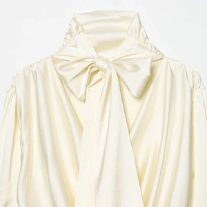 Elegante cremeweiße Satinbluse für Damen mit Stehkragen und großer Schleife am Halsausschnitt