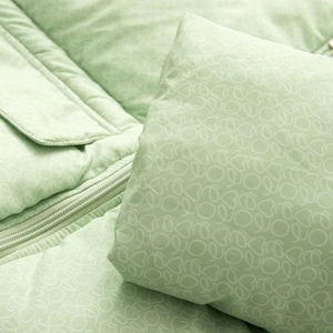 Détail d'une veste matelassée vert clair avec motif cœurs et fermeture éclair en métal