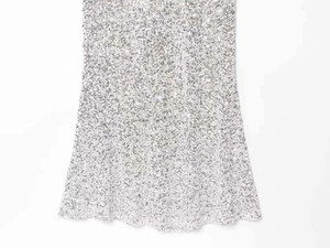 Detailed view of silver sequin dress hemline with shimmering metallic finish fabric