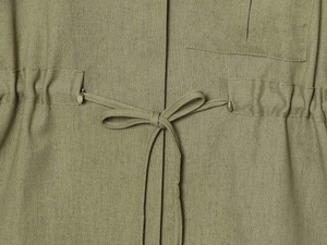Detail of olive green fabric featuring adjustable drawstring waist and square patch pocket