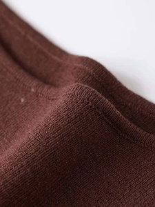 Macro shot of dark brown knit fabric texture and seam detail for sleeveless top