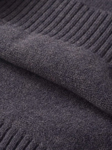 Detailed macro view of dark grey knit texture with ribbed hem on a high neck short sleeve top