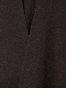 Detailed macro view showing the thick brown wool fiber texture and V-neck seam of the poncho