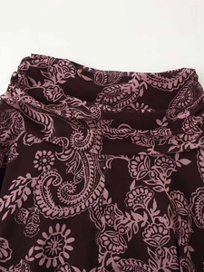 Gros plan sur le tissu en mousseline bordeaux avec motifs cachemire et fleurs roses