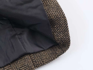 Macro detail of brown herringbone wool blend fabric with black inner lining for women blazer