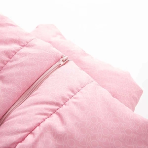 Détail de la veste d'hiver rose avec motifs cœurs blancs et fermeture éclair assortie