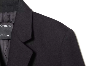 Detail view of the notch lapel and interior label on this cropped black blazer jacket