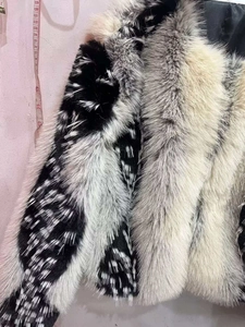 Detail shot of fluffy faux fur texture with black and white spotted patterns