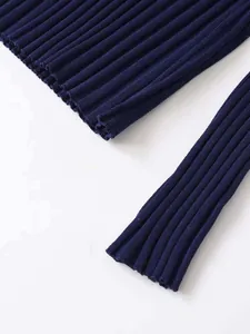 Detail view of the vertical ribbed texture and hem on a navy blue knit sweater