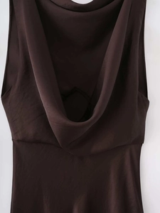 Detail of a deep brown satin mini dress showing the elegant cowl back draped design