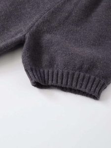 Detail of dark grey knit fabric with ribbed edges and fine texture on a short sleeve top