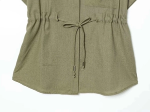 Detail of olive green jacket with adjustable drawstring waist and metal tip accents