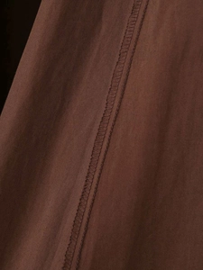 Macro shot of precise stitching and hem details on brown vintage A-line cotton dress