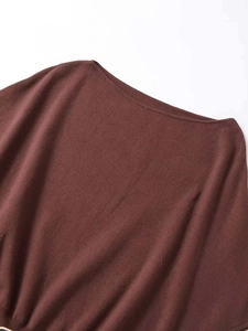 Detailed close-up of dark brown knit sweater neckline with elegant off-shoulder design