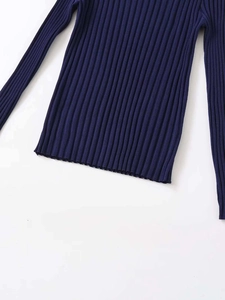 Detailed view of the navy blue ribbed knit texture and bottom hem of the long sleeve sweater