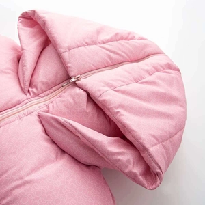 Détail de la veste d'hiver rose avec motif de cœurs matelassés et fermeture éclair assortie