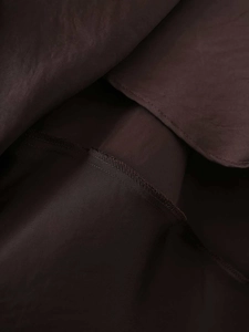 Detail of dark brown silk texture fabric showing fine stitching and layered lining