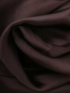 Detail of silk satin fabric texture in chocolate brown with elegant light draping