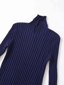 Detail of navy high neck knit sweater featuring a teardrop cutout and ribbed texture