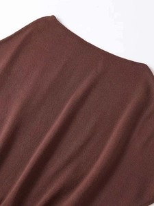 Detailed macro view of dark brown knitted fabric texture and neckline finish of the top