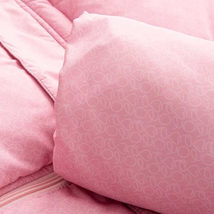 Gros plan sur tissu matelassé rose à motifs cœurs montrant la texture douce et les coutures