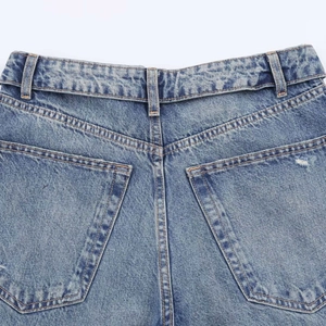 Détail de ce pantalon en jean bleu délavé à taille haute avec poches arrière et surpiqûres