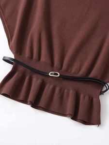 Detail of dark brown knit top with a slim black belt and golden oval buckle design