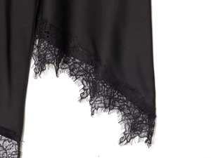 Détail de la jupe en satin noir avec bordure en dentelle de cils et couture raffinée