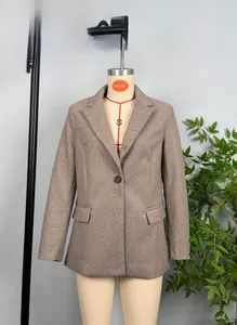 Detail of a brown herringbone blazer featuring notch lapels and classic flap pockets