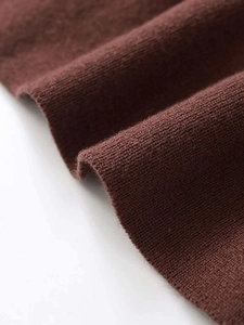 Macro detail of dark brown knitted fabric texture with soft folds and high elasticity