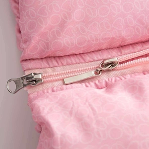 Détail d'une veste matelassée rose avec double fermeture éclair en métal argenté et motifs