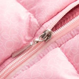 Détail d'une doudoune rose avec surpiqûres en forme de cœur et fermeture éclair argentée