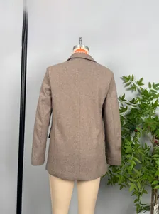 Close-up view of brown herringbone tweed blazer showing premium texture and straight cut