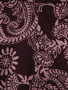 Détail du tissu en mousseline bordeaux avec motifs paisley roses et texture gaufrée légère