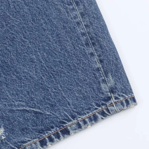 Détail du tissu denim bleu avec coutures orange et effet de délavage vintage élégant