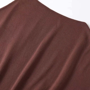 Minimalist dark brown knitted top featuring a textured fabric and stylish waist belt