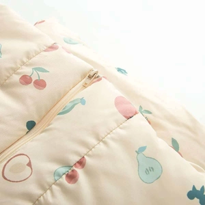 Détail d'un tissu en coton doux avec motifs de fruits et fermeture éclair en nylon robuste